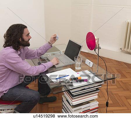 Man using laptop, holding credit card View Large Photo Image Stock Photo - Man using laptop, holding credit card. Fotosearch