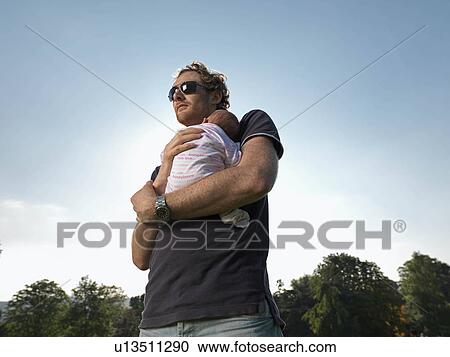 Stock Image - Man with baby in park. Fotosearch