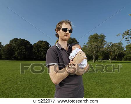 Man with baby in park View Large Photo Image Stock Photo - Man with baby in park. Fotosearch