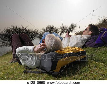 Stock Photo - man & woman on phone during hike. Fotosearch