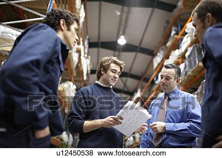 Stock Photo - Manager and workers in warehouse. Fotosearch
