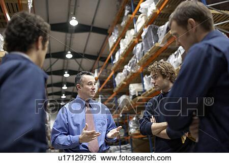 Stock Photograph - Manager and workers in warehouse. Fotosearch