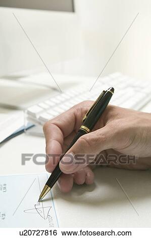 Stock Photograph - Man's hand signing a check. Fotosearch