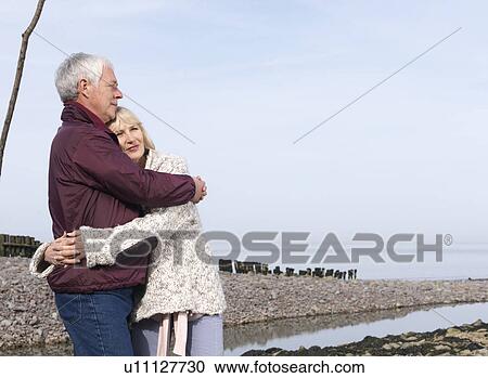 mature couple hugging on beach View Large Photo Image Stock Image - mature couple hugging on beach. Fotosearch