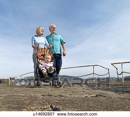 mature couple pushing child in buggy View Large Photo Image Stock Photo - mature couple pushing child in buggy. Fotosearch