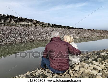 mature couple sitting on beach View Large Photo Image Stock Image - mature couple sitting on beach. Fotosearch