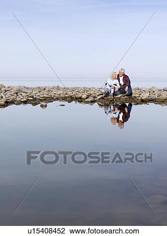 mature couple sitting on beach View Large Photo Image Stock Image - mature couple sitting on beach. Fotosearch