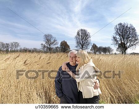 Stock Photography - mature couple standing in field. Fotosearch