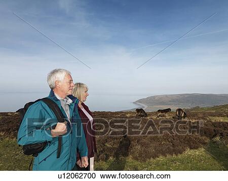 Stock Image - mature couple walking on moor. Fotosearch