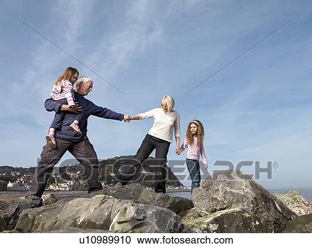 Stock Image - mature couple with child on beach. Fotosearch