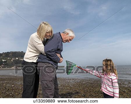 Stock Photo - mature couple with child on beach. Fotosearch