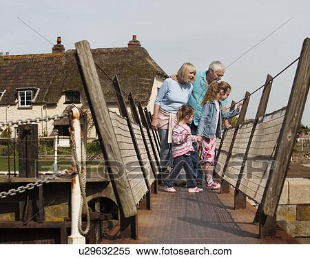 Stock Photography - mature couple with children on walkway. Fotosearch