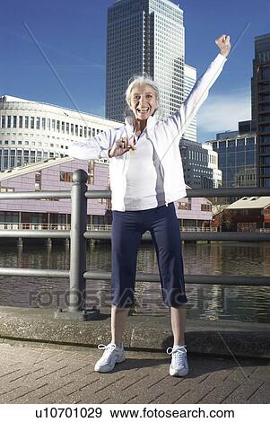 Stock Photo - mature lady with medal cheering. Fotosearch