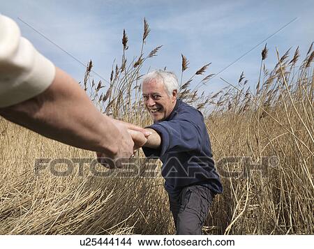 mature man getting helping hand in field View Large Photo Image Picture - mature man getting helping hand in field. Fotosearch