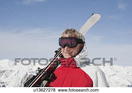 Mature man holding ski's View Large Photo Image Stock Photo - Mature man holding ski's. Fotosearch