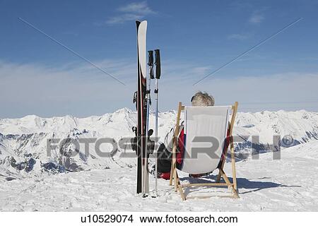 Mature man sitting on deck chair View Large Photo Image Picture - Mature man sitting on deck chair. Fotosearch