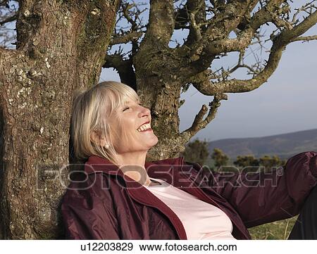 mature woman leaning against tree View Large Photo Image Stock Photo - mature woman leaning against tree. Fotosearch