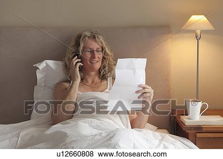 Mature woman on the phone in bed View Large Photo Image Stock Photo - Mature woman on the phone in bed. Fotosearch