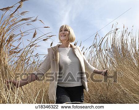 mature woman walking in reeds View Large Photo Image Stock Image - mature woman walking in reeds. Fotosearch