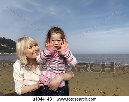 Stock Image - mature woman with child on beach. Fotosearch
