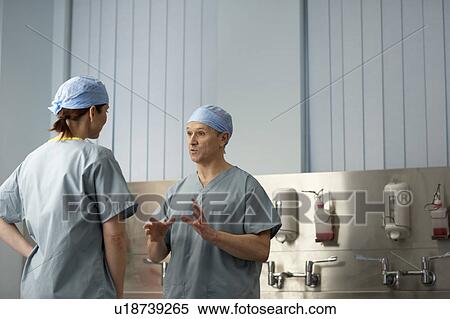 Stock Photography - Medical staff in scrubs in discussion. Fotosearch
