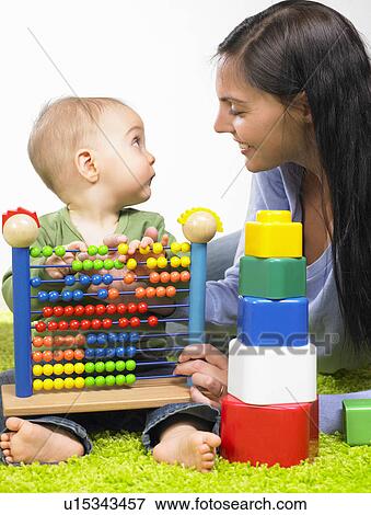 Stock Photo - Mother and baby boy playing. Fotosearch