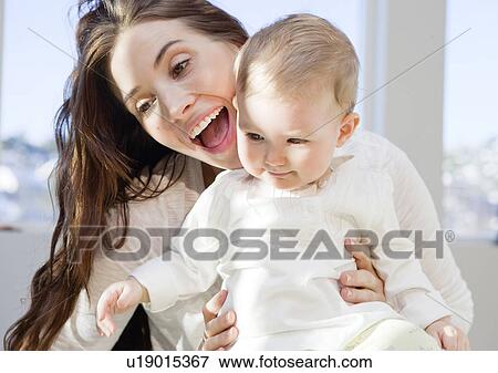 Stock Photo - Mother and baby cuddling and playing. Fotosearch