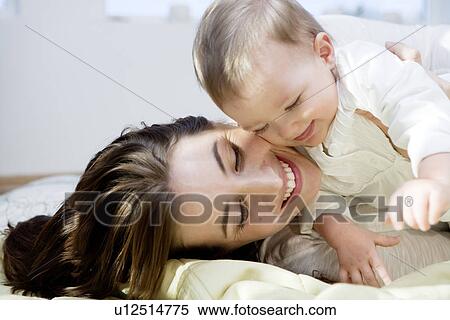 Mother and baby cuddling and playing View Large Photo Image Stock Photography - Mother and baby cuddling and playing. Fotosearch