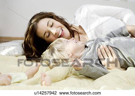 Mother and children cuddling and playing View Large Photo Image Stock Image - Mother and children cuddling and playing. Fotosearch