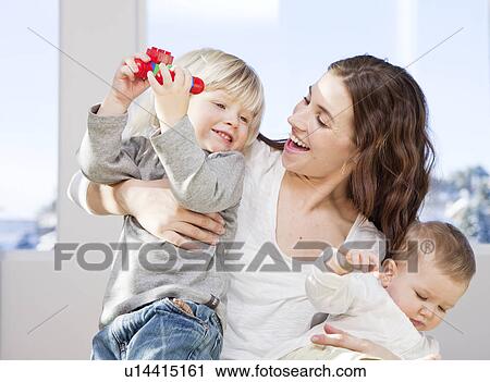 Mother and children cuddling and playing View Large Photo Image Stock Image - Mother and children cuddling and playing. Fotosearch