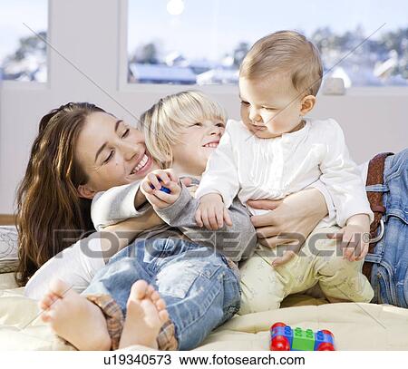 Mother and children cuddling and playing View Large Photo Image Stock Image - Mother and children cuddling and playing. Fotosearch