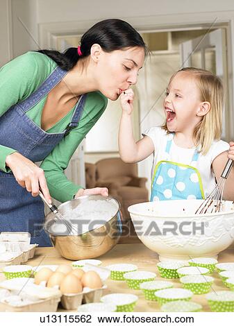 Stock Image - Mother and daughter cooking. Fotosearch