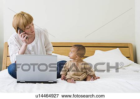 Mother & baby on bed View Large Photo Image Stock Photo - Mother & baby on bed. Fotosearch
