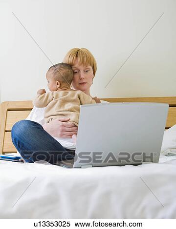Stock Photography - Mother & Baby on bed. Fotosearch