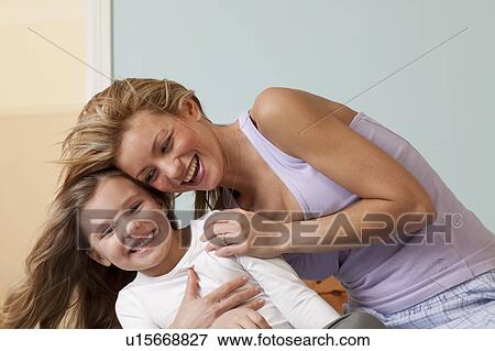 Stock Photo - mother hugging girl. Fotosearch