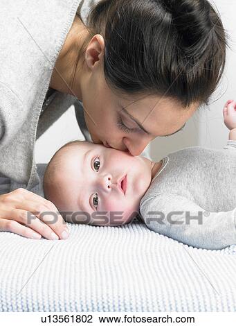 Stock Image - Mother kissing her baby-boy. Fotosearch