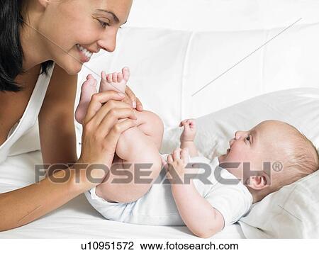 Mother kissing her new-born baby's feet View Large Photo Image Stock Image - Mother kissing her new-born baby's feet. Fotosearch