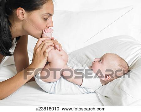 Mother kissing her new-born baby's feet View Large Photo Image Stock Image - Mother kissing her new-born baby's feet. Fotosearch