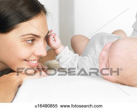 Stock Photography - Mother looking at her baby. Fotosearch
