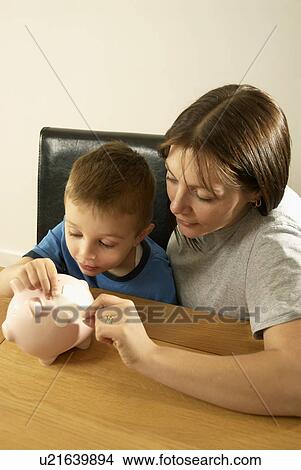 mum and son repair piggy bank View Large Photo Image Picture - mum and son repair piggy bank. Fotosearch