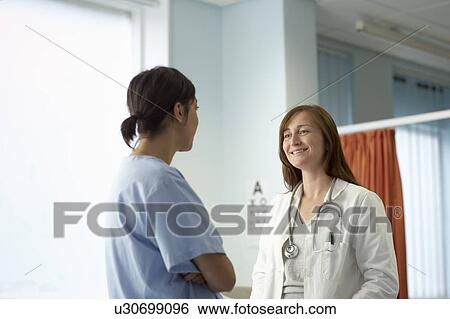 Nurse and doctor in discussion View Large Photo Image Stock Photograph - Nurse and doctor in discussion. Fotosearch