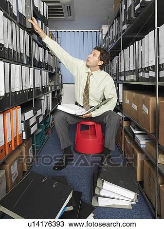 Stock Image - Office worker surrounded by files. Fotosearch