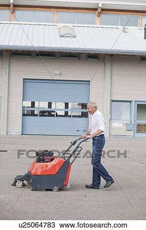 Stock Image - old man cleaning courtyard. Fotosearch