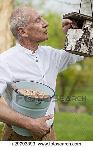 old man filling up bird house View Large Photo Image Stock Image - old man filling up bird house. Fotosearch