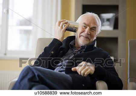 Stock Photo - old man playing with can phone. Fotosearch