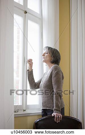old woman standing at window View Large Photo Image Stock Image - old woman standing at window. Fotosearch