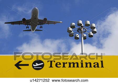 Plane flying over 'terminal' sign View Large Photo Image Stock Image - Plane flying over 'terminal' sign. Fotosearch