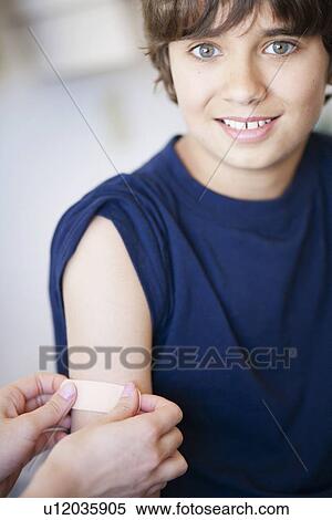 Stock Photography - Plaster/bandage put on smiling young boy. Fotosearch