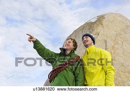 Stock Image - Portrait of 2 climbers, one pointing. Fotosearch