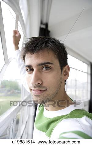 Portrait of a man alongside a window. View Large Photo Image Picture - Portrait of a man alongside a window.. Fotosearch